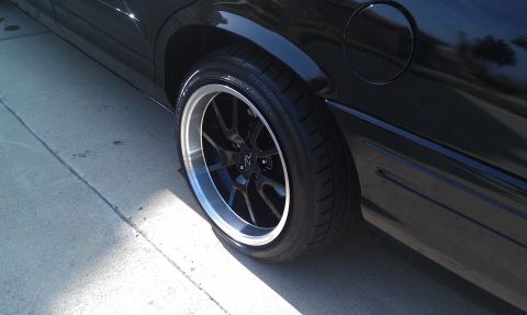 2003 Ford Crown Victoria - Rear wheel detail of a black Crown Victoria, polished-lip alloy and low-profile tire on concrete