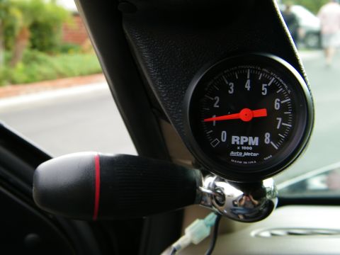 2003 Ford Crown Victoria - Black AutoMeter tach on an A-pillar pod inside a vehicle, racing-style shifter handle nearby