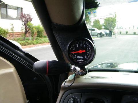 2003 Ford Crown Victoria - Pillar-mounted AutoMeter RPM gauge viewed across the dash, parking lot through the windshield