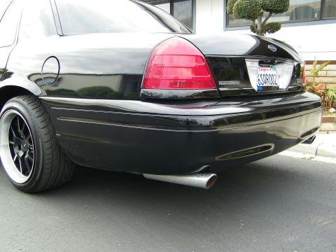 2003 Ford Crown Victoria - Low rear-corner shot of a black Crown Victoria with tinted taillight and dark wheel