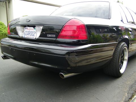 2003 Ford Crown Victoria - Angled rear view of a black Crown Victoria Limited showing trunk badge and machined-lip wheel