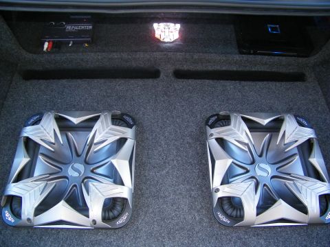 2003 Ford Crown Victoria - Pair of Kicker subwoofers flanking center, bass processor mounted on the rear shelf
