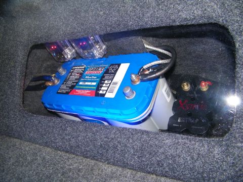 2003 Ford Crown Victoria - Optima yellow-top battery with power terminals set into a carpeted trunk cavity