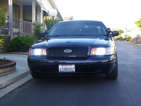 2003 Ford Crown Victoria - Front view of a black Crown Victoria Police Interceptor at curbside with lights on