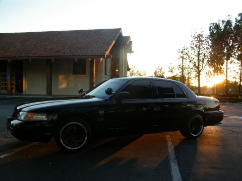 2003 Ford Crown Victoria - Full side view of a lowered black Crown Victoria in a parking lot during golden hour