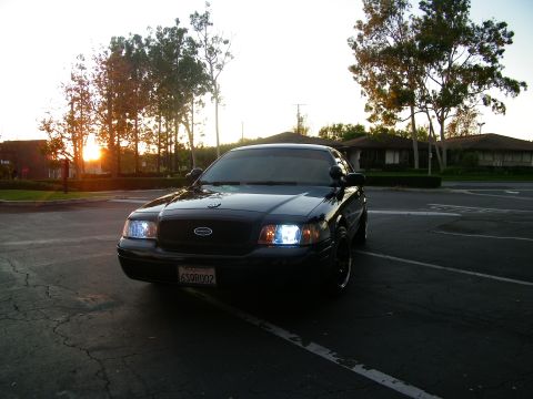 2003 Ford Crown Victoria - Front-end shot of a blacked-out Crown Victoria Police Interceptor in an empty parking lot at sunset.