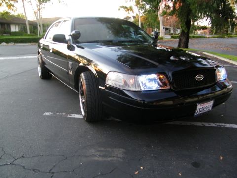 2003 Ford Crown Victoria - Low ground-level front-quarter shot of a black Ford sedan in a parking lot.