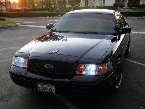 2003 Ford Crown Victoria - Front-quarter shot of a black Interceptor with HID headlights in a parking lot at sunset.