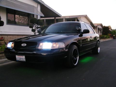 2003 Ford Crown Victoria - Black Ford sedan with green underbody lighting parked in front of a mid-century house.