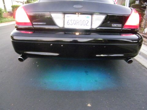 2003 Ford Crown Victoria - Rear view of a black Crown Victoria showing dual exhaust and POLICE INTERCEPTOR badge.