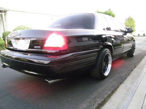 2003 Ford Crown Victoria - Rear-quarter view of a black Ford sedan with red underglow and dual exhaust tips.