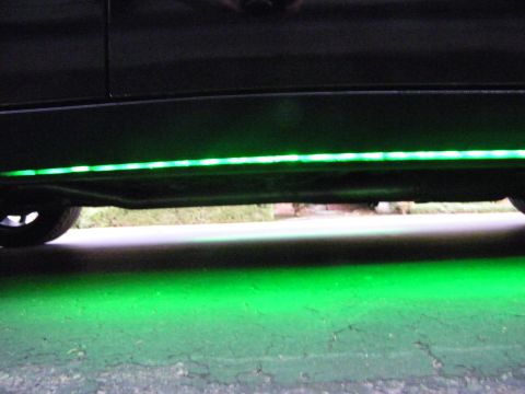 2003 Ford Crown Victoria - Green LED light strip mounted under a black car's side sill, illuminating the wheel and ground.