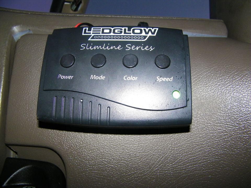 LEDGlow Slimline Series LED controller with Power Mode Color Speed buttons on tan car panel
