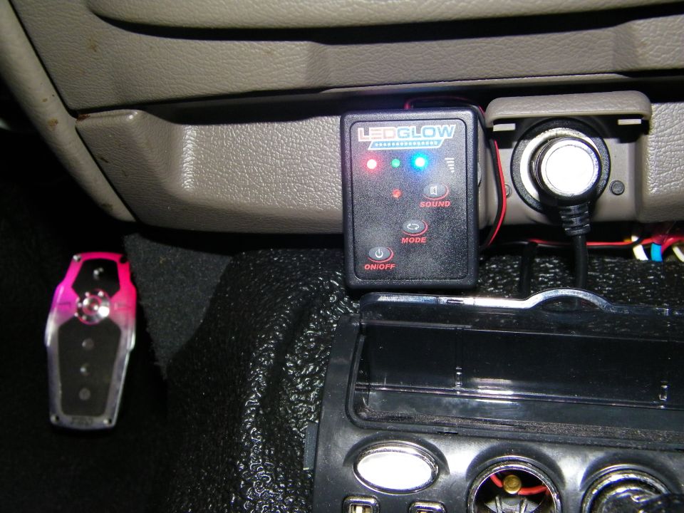 LEDGlow controller with red green blue LEDs mounted on car interior near outlet and gauge pod