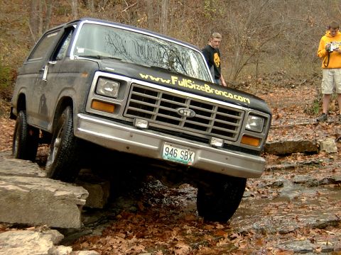 1982 Ford Bronco - Ford Bronco tackles an off-road obstacle with two onlookers present.