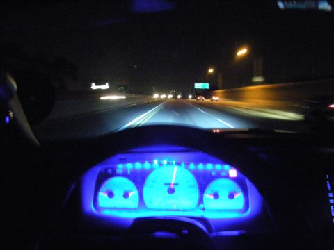 2003 Ford Crown Victoria - Driver POV on dark highway with blue glowing instrument cluster and oncoming headlights