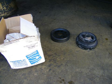 2003 Ford Crown Victoria - Two pulleys next to an open Genuine Steeda parts box on a concrete garage floor