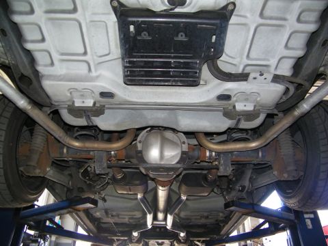2003 Ford Crown Victoria - Rear undercarriage with center muffler, dual pipes and rear axle on a shop lift