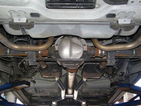 2003 Ford Crown Victoria - Close view of rear axle differential and routed dual exhaust under a lifted vehicle