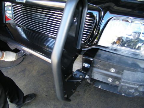 2003 Ford Crown Victoria - Detail of a black grille guard bracket mounted next to the billet grille and headlight