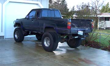 1980 Ford Bronco - This black pickup truck is modified with a lifted suspension and dual rear wheels.