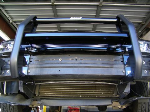 2003 Ford Crown Victoria - Low-angle shot of front grille guard tubing, crossmember and radiator from beneath a raised vehicle