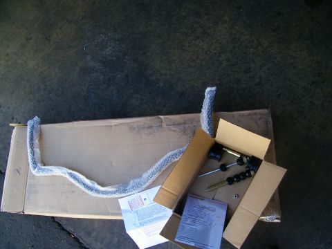 2003 Ford Crown Victoria - Top-down view of packaging foam, bagged hardware and a printed sheet laid out on shop concrete