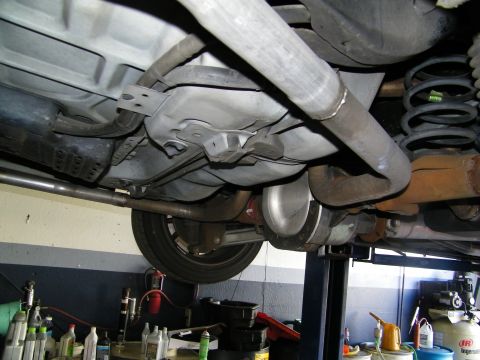 2003 Ford Crown Victoria - Undercarriage view with fuel tank, welded exhaust, suspension coil and brake components overhead