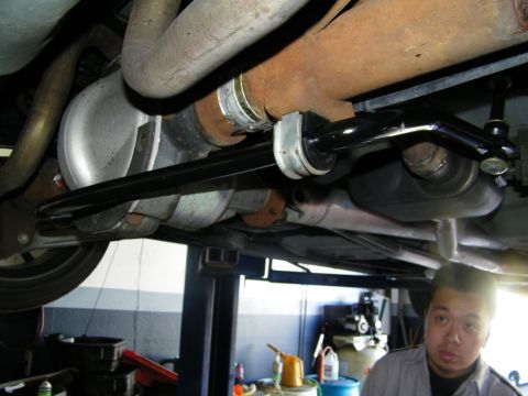 2003 Ford Crown Victoria - Installed anti-roll bar spanning the undercarriage, mechanic and shop fluids in the lower frame