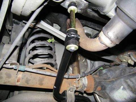 2003 Ford Crown Victoria - Close-up of an anti-roll bar end link joined to the coil spring and lower control arm assembly