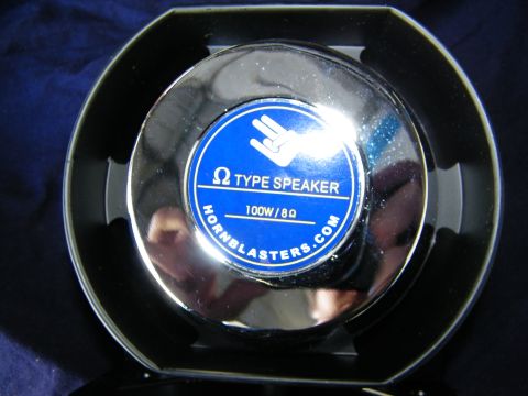 2003 Ford Crown Victoria - Detail of chrome speaker face with blue HornBlasters.com label against dark blue cloth