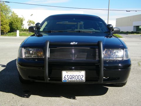 2003 Ford Crown Victoria - Head-on shot of black Crown Victoria showing billet grille and police push bumper.
