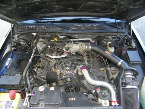 2003 Ford Crown Victoria - Open engine compartment showing a modified 4.6L V8 with aftermarket intake piping.