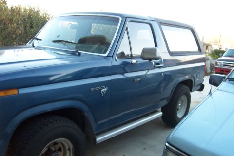 1980 Ford Bronco - Side view of a blue 1980 Ford Bronco with running boards.