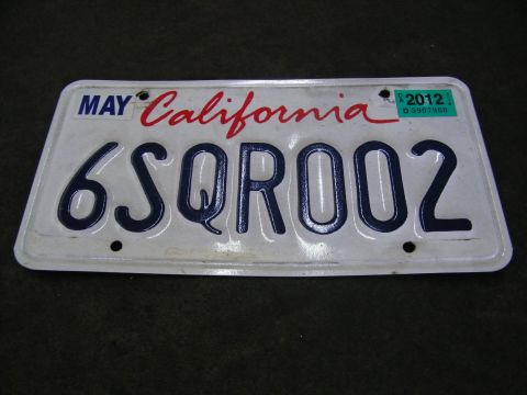 2003 Ford Crown Victoria - White California plate reading 6SQR002 photographed on a dark surface, 2012 tag.