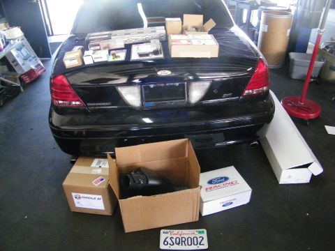 2003 Ford Crown Victoria - Crown Victoria in a shop surrounded by Ford Racing, Circle D and intake parts boxes.