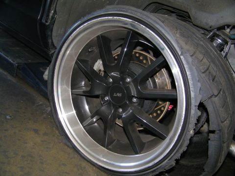 2003 Ford Crown Victoria - Matte-black LAS wheel with machined lip over a cross-drilled rotor and red brake caliper.