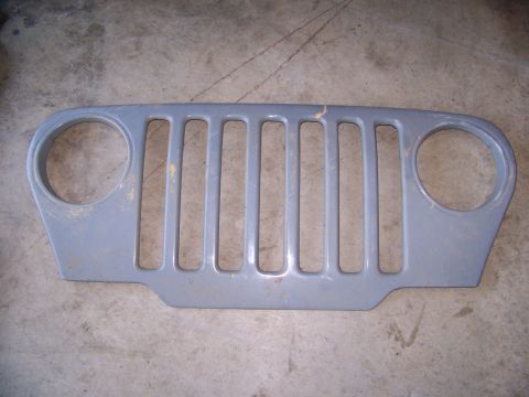 2000 Jeep Wrangler - A gray Jeep grille is shown lying on a concrete floor. The Supermotors.net logo is visible in the lower right corner.