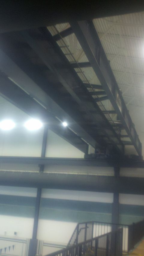1988 Ford Bronco - An industrial overhead crane system is visible against the building's ceiling and lights.