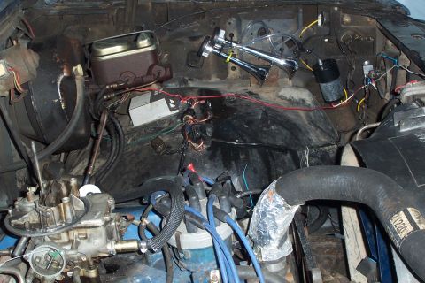 1980 Ford Bronco - Close-up of an engine bay, a carburetor, distributor, and brake fluid reservoir.
