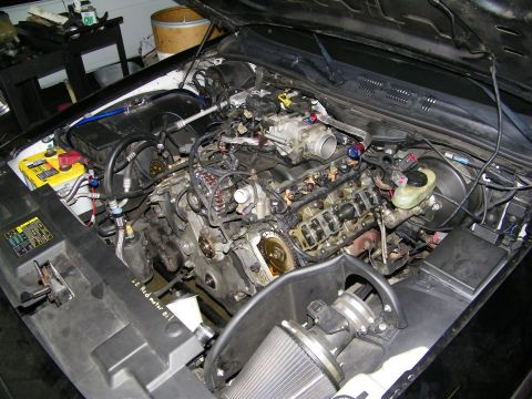 2003 Ford Crown Victoria - Engine compartment mid-teardown showing exposed cylinder head and intake manifold