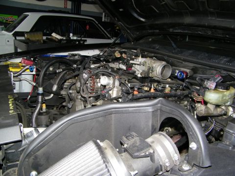2003 Ford Crown Victoria - Workshop engine bay showing a conical air filter intake and partly stripped engine