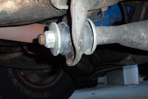 1980 Ford Bronco - This image shows a close-up view of a suspension component and part of the exhaust system underneath a vehicle.
