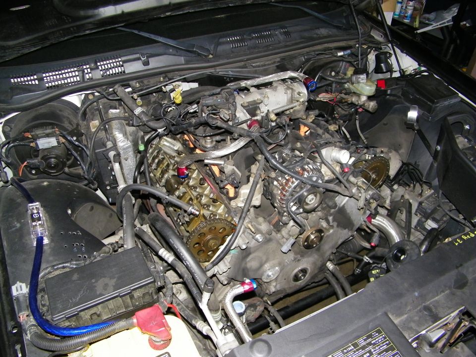 Disassembled V8 engine showing exposed timing gear and intake during rebuild
