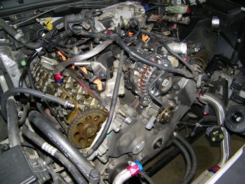 2003 Ford Crown Victoria - Engine teardown showing front timing gears, alternator and stripped block in bay
