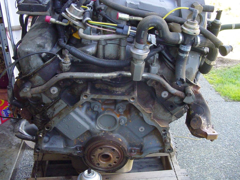 Ford fuel-injected V8 engine removed from truck, on a wooden pallet with front accessories stripped