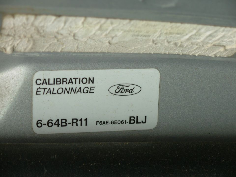 Ford calibration decal reading 6-64B-R11 and F6AE-6E061-BLJ on a gray underhood panel
