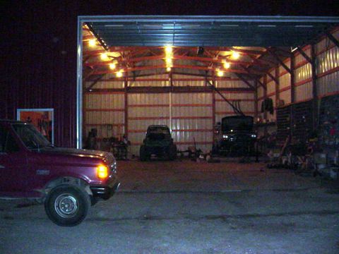 1992 Ford Bronco - A maroon 1992 Ford Bronco is parked in a garage with other vehicles visible inside.