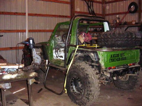 1992 Ford Bronco - This heavily modified off-road vehicle features a custom roll cage and oversized tires, with contact information visible on the tailgate.