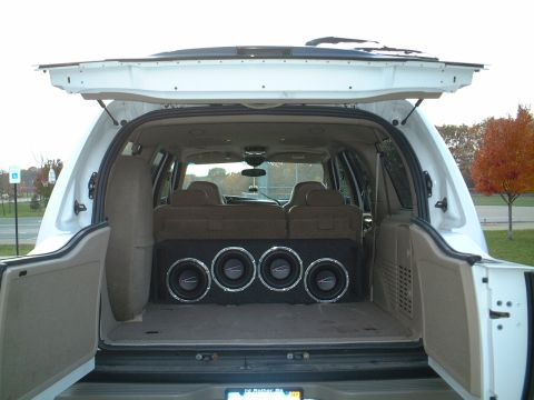 2000 Ford Excursion - The rear cargo area of a white 2000 Ford Excursion features a custom subwoofer box with four speakers.